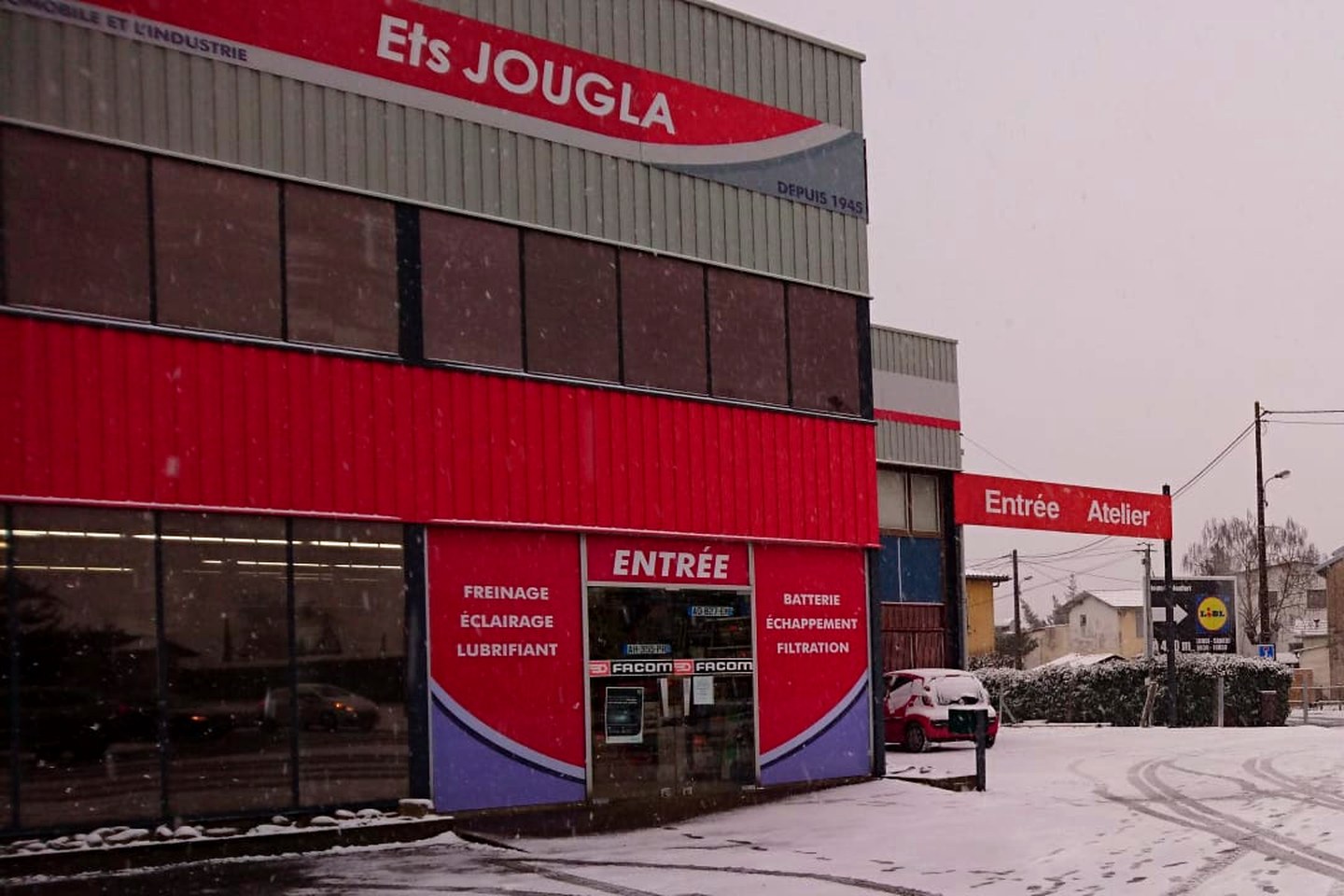 La façade des Etablissements Jougla, 109 rue de la Croix Blanche à Dax : l'enseigne rouge « Ets JOUGLA, depuis 1945 » au-dessus de l'entrée du magasin.